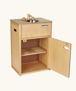 PlanToys wooden play sink kitchen unit. The counter top featuers a metal bowl sink and taps, a cut out handle door with a slotted shelf inside. 