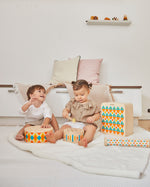 2 children sat on the floor playing with the PlanToys plastic-free wooden musical toys
