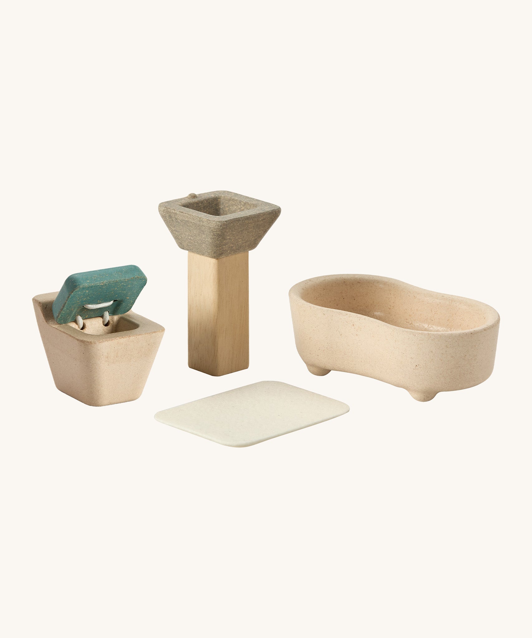A close up view of the PlanToys wooden toilet with the seat up, sink bath and rug that go with the bathroom set