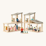 A full dollhouse setup including the PlanToys space bathroom, kitchen and living room sets with various PlanToys family dolls