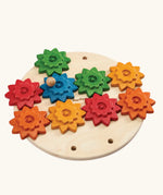 PlanToys spinning gear wooden toy playset. Wooden base with 9 coloured gears.