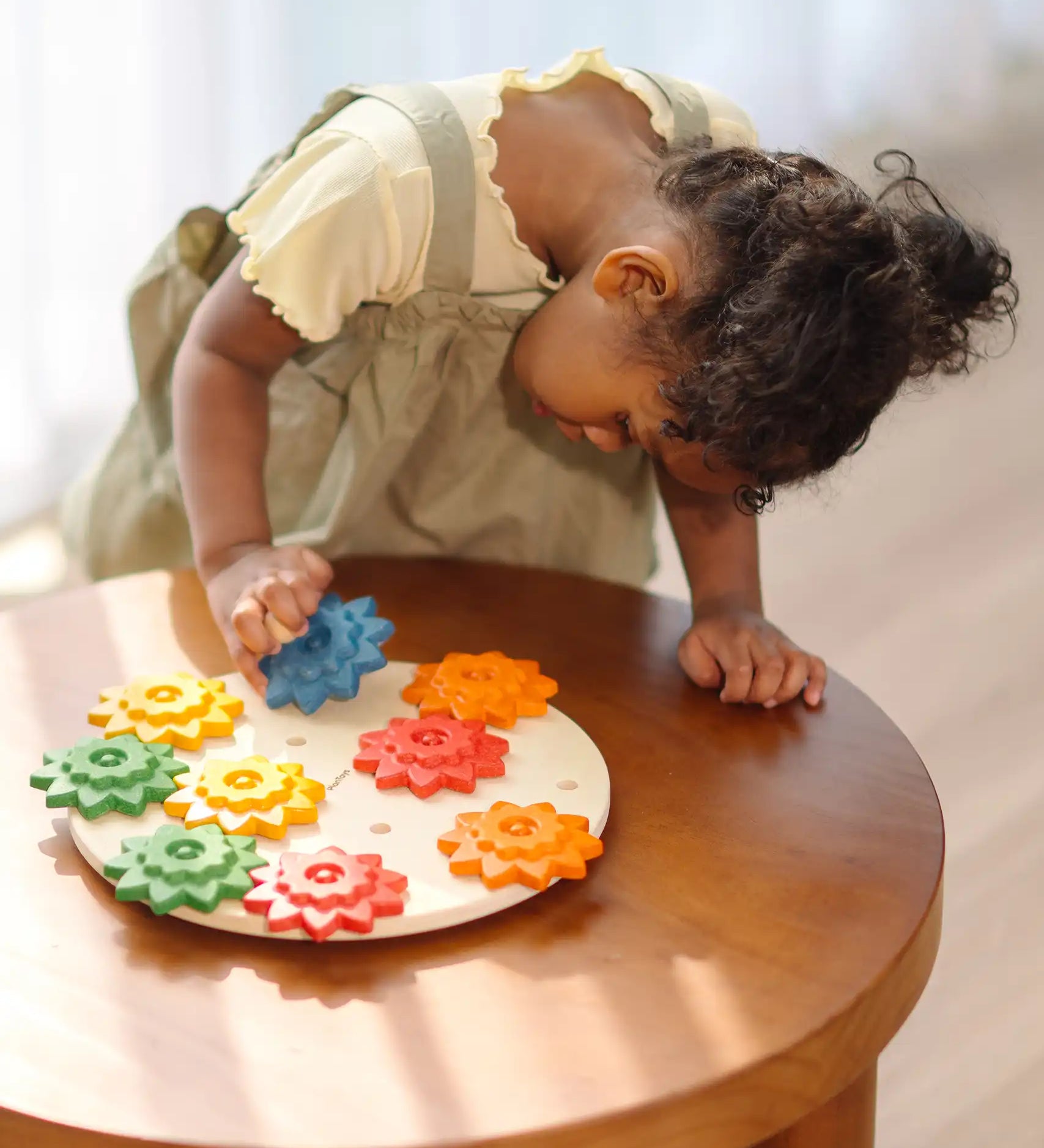 Child playing with the PlanToys spinning gear wooden toy playset.