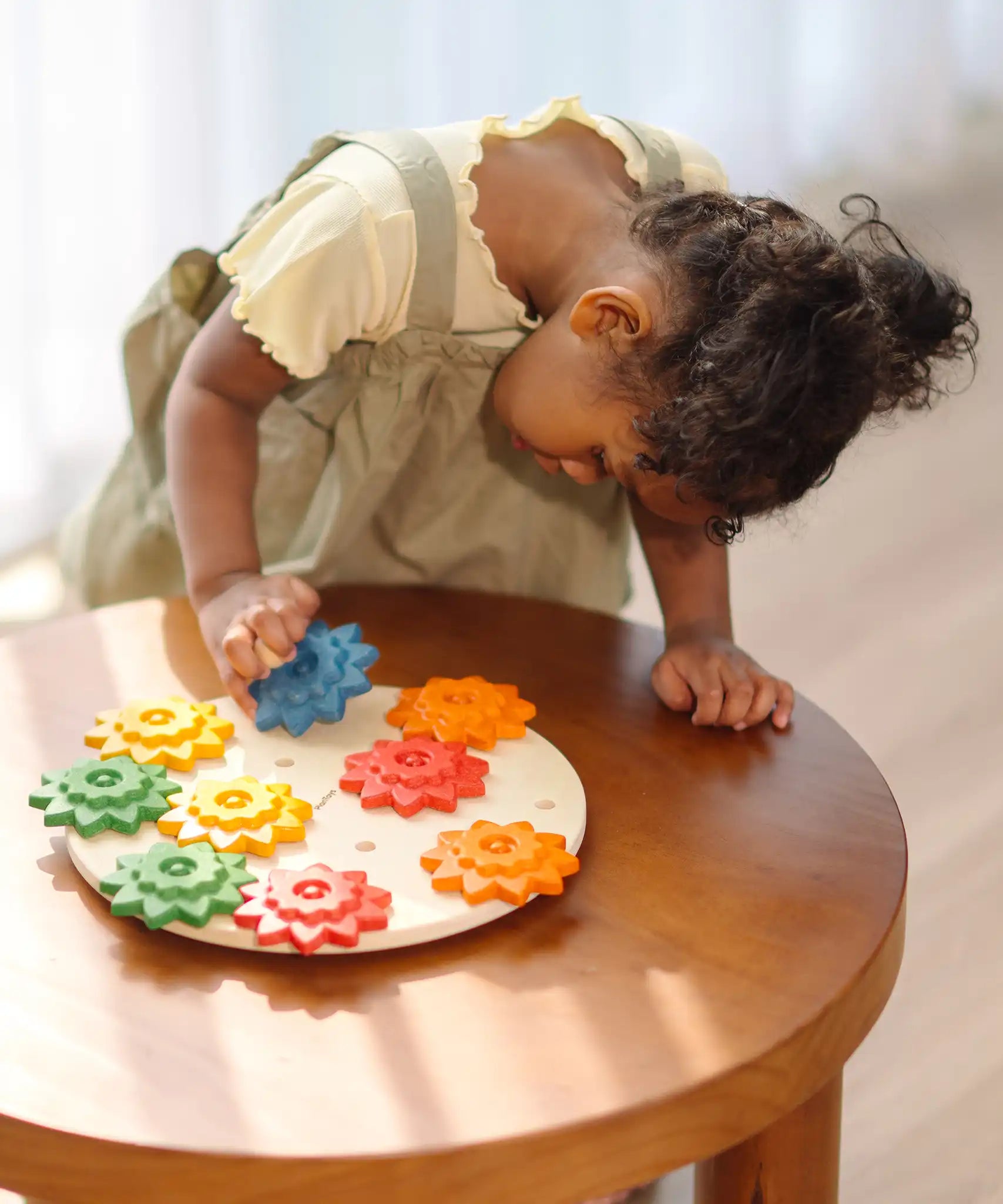 Child playing with the PlanToys spinning gear wooden toy playset.