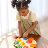 Child playing with the PlanToys spinning gear wooden toy playset.
