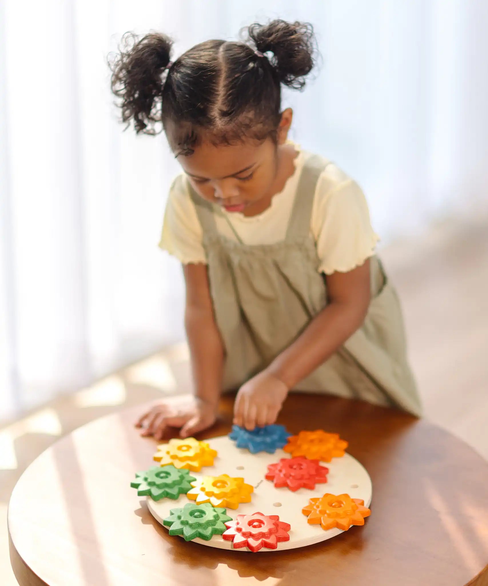 Child playing with the PlanToys spinning gear wooden toy playset.