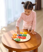 Child playing with the PlanToys spinning gear wooden toy playset.