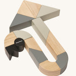 The PlanToys Twisted Blocks laid out to create an arrow shape on a plain background. 