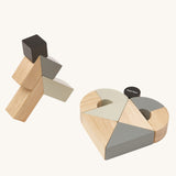 The PlanToys Twisted Blocks stacked up on a plain background.  Some of the blocks have been laid out to create a heart shape. 