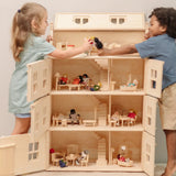 Children playing with the PlanToys Grand Victorian Dollhouse. Front and roof shown open and all floors and attic room has PlanToys dolls house furniture inside.