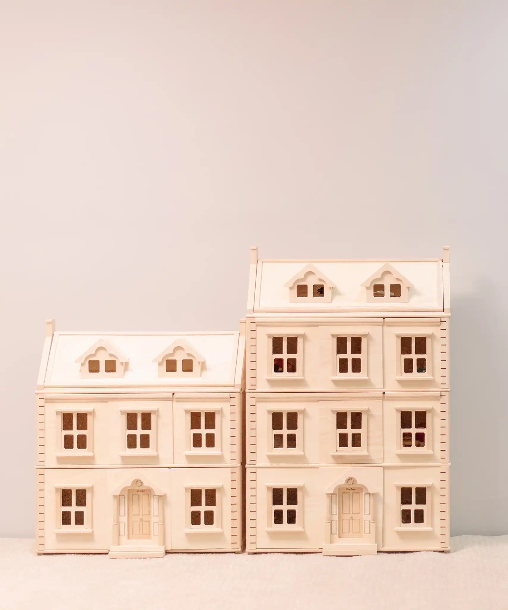 PlanToys Grand Victorian Dollhouse pictured next to the smaller standard size house.