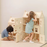 Children playing with the PlanToys Grand Victorian Dollhouse. The smaller Victorian dolls house is next to it.