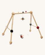 PlanToys High Contrast Wooden Baby Play Gym. A wooden baby gym with high contrast coloured features and detailing. The gym comes with two wooden hanging toys, a planet and a rocket. PlanToys range of toys are made from sustainably sourced rubberwood, we're proud stockists of PlanToys here at Babipur. 