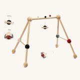 PlanToys High Contrast Wooden Baby Play Gym. A wooden baby gym with high contrast coloured features and detailing. The gym comes with two wooden hanging toys, a planet and a rocket. PlanToys range of toys are made from sustainably sourced rubberwood, we're proud stockists of PlanToys here at Babipur. 