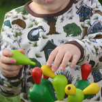 A close up of a child's hands playing with the  PlanToys Balancing Cactus.