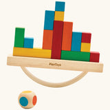 Close-up of hands carefully stacking cargo blocks onto the rocking base