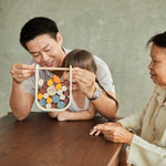 Close up of hands grabbing pieces of the PlanToys stacking wooden beaver tumble kids game