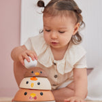 A child playing with the modern rustic colour PlanToys Chicken Nesting toy. 
