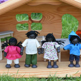The PlanToys doll house family set placed in an Ostheimer dolls house. The dolls have black skin and black hair.