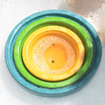 PlanToys Fountain Bowl Set nestled inside each other in a tub of bubbly water.