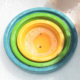 PlanToys Fountain Bowl Set nestled inside each other in a tub of bubbly water.