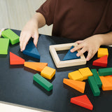 Close up of child's hands playing with the PlanToys solid wooden fraction blocks on a wooden table