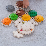 A close up of a child's hand playing with the PlanToys Gear and Puzzle. 