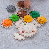 A close up of a child's hand playing with the PlanToys Gear and Puzzle. 