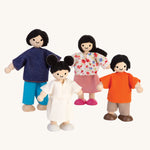 The PlanToys Dolls House Family with White Skin and Black Hair on a plain background. 