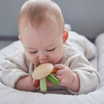 Close up of a baby holding the PlanToys flexi jellyfish baby teething toy close to its mouth
