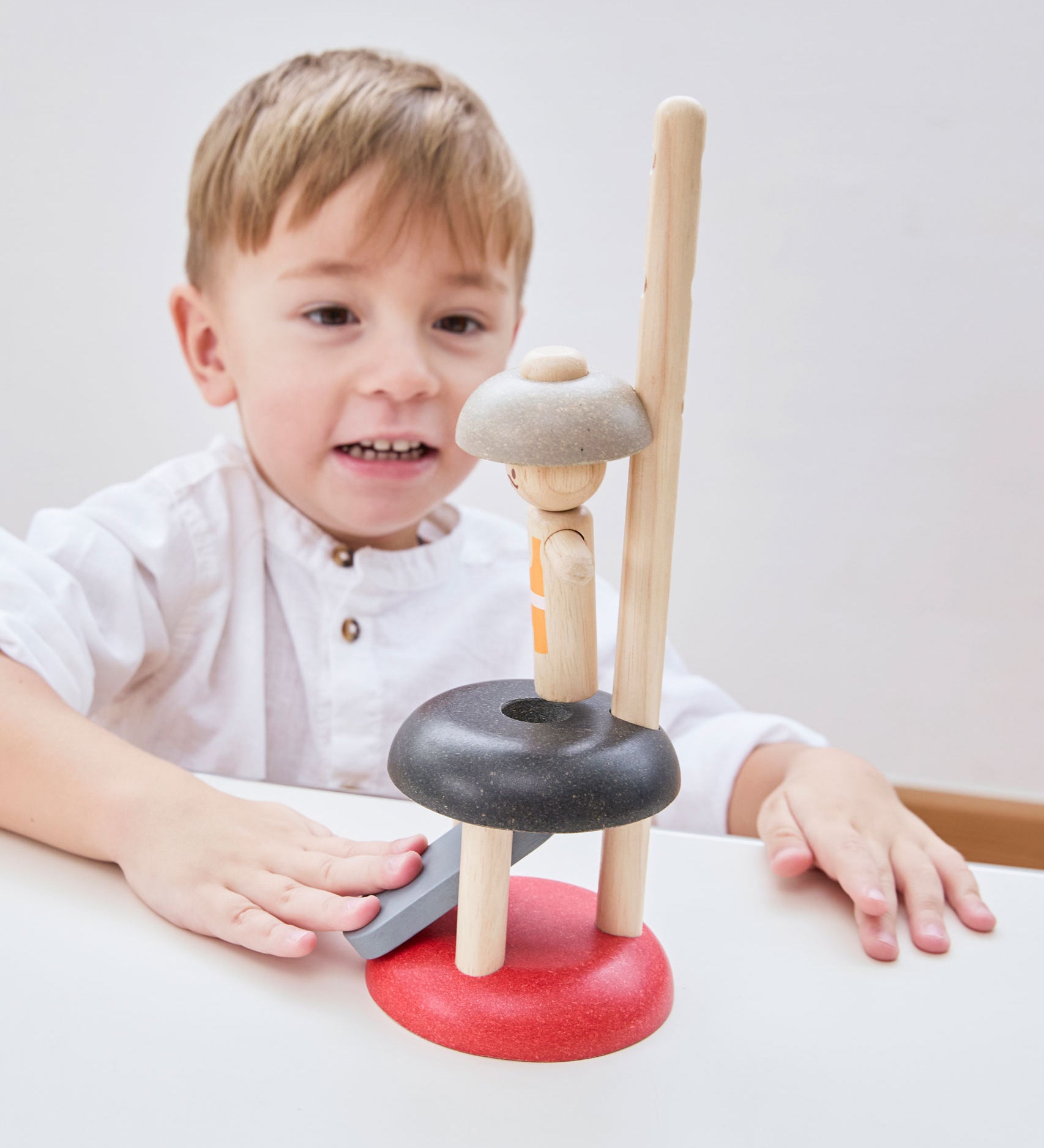 A child playing with the PlanToys Natural Rubberwood Jumping Acrobat Toy. PlanToys have a vast range of sustainable wooden toys are available at Babipur.