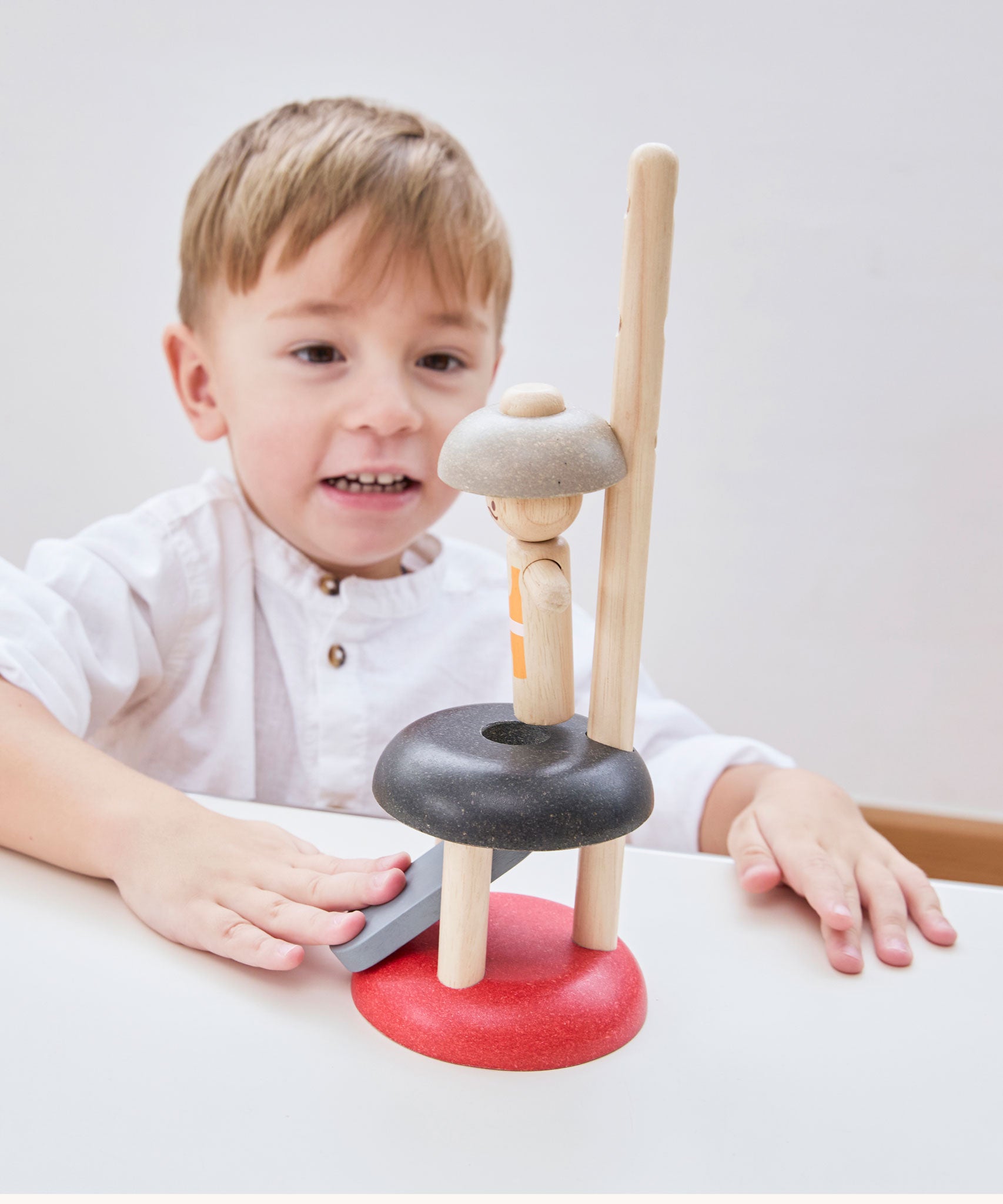 A child playing with the PlanToys Natural Rubberwood Jumping Acrobat Toy. PlanToys have a vast range of sustainable wooden toys are available at Babipur.