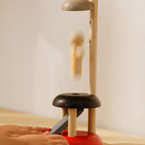 A close up of a child's hand playing with the PlanToys Natural Rubberwood Jumping Acrobat Toy. PlanToys have a vast range of sustainable wooden toys are available at Babipur.