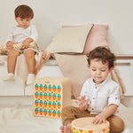 2 children sat down playing with the PlanToys solid wooden musical drum toy