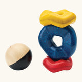 PlanToys wave ball stacker wooden stacking toy. Blue, yellow and red wavy rings with a black and white ball. 