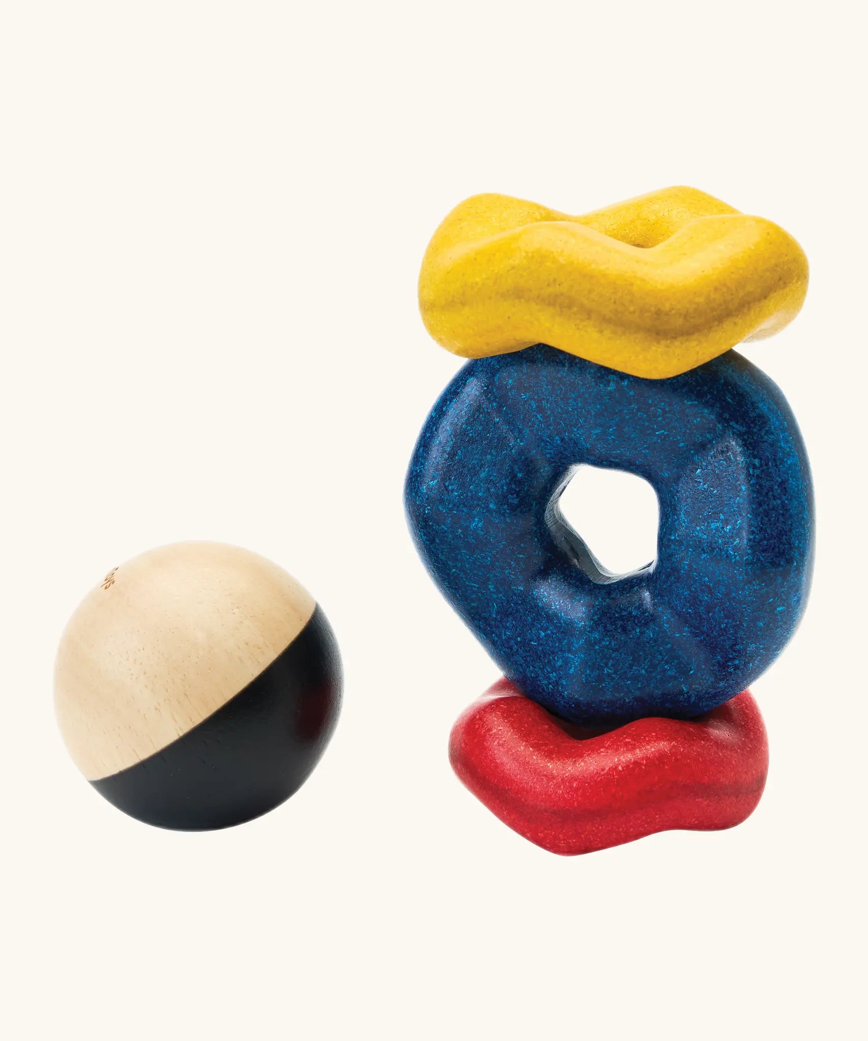 PlanToys wave ball stacker wooden stacking toy. Blue, yellow and red wavy rings with a black and white ball. 