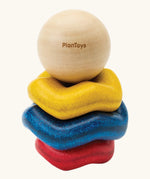 Wooden ring stacking toy for babies by PlanToys. Blue, yellow and red wavy rings with a black and white ball. 