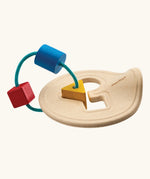 Toddler holding up the wooden shape sorter to inspect the pieces
