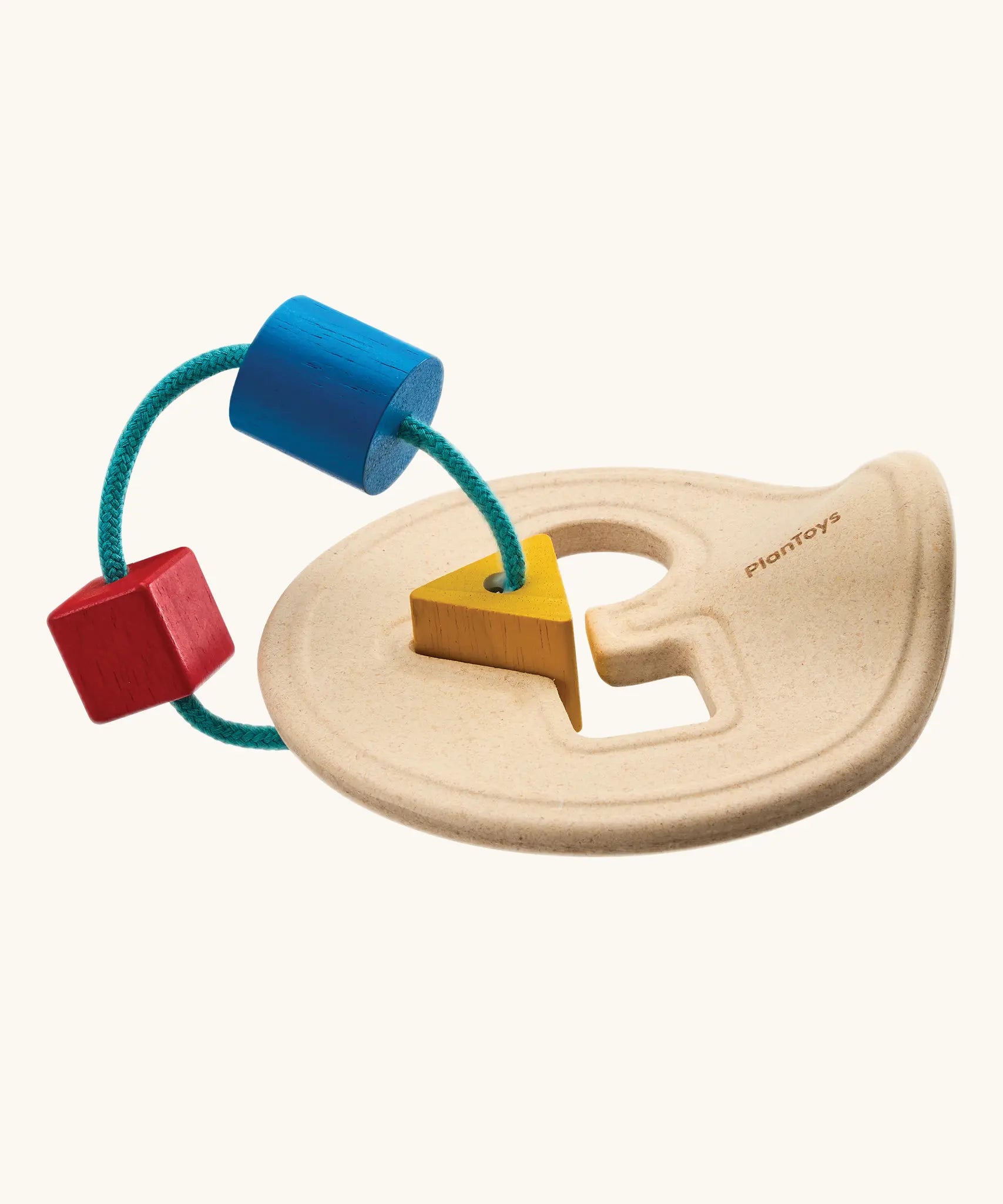 Toddler holding up the wooden shape sorter to inspect the pieces