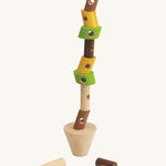 The PlanToys Stacking Logs Game on a plain background with the logs all stacked in a tall stack on the base piece. 