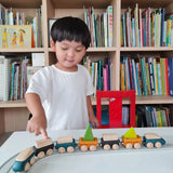 Child playing with PlanToys blue wooden trains on a rubber railway tracks. 