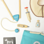 A simple flatlay on a white surface with all the pieces from the Plan Toys Play Vet Set. 