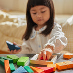 Close up of young child playing with the PlanToys Waldorf fraction blocks toy set