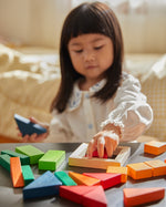 Close up of young child playing with the PlanToys Waldorf fraction blocks toy set
