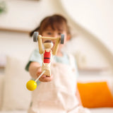 Child playing with the PlanToys Weightlifting Acrobat wooden toy.