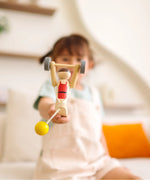 Child playing with the PlanToys Weightlifting Acrobat wooden toy.