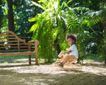 Toddler sat on the wooden foldable rocking horse by PlanToys. Front view.