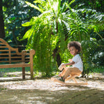 Toddler sat on the wooden foldable rocking horse by PlanToys. Front view.