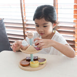 two tiers of cakes and biscuits play food. White background.