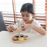 two tiers of cakes and biscuits play food. White background.