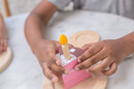 The PlanToys wooden birthday cake showing the different combinations of strawberry or chocolate cake. White background.